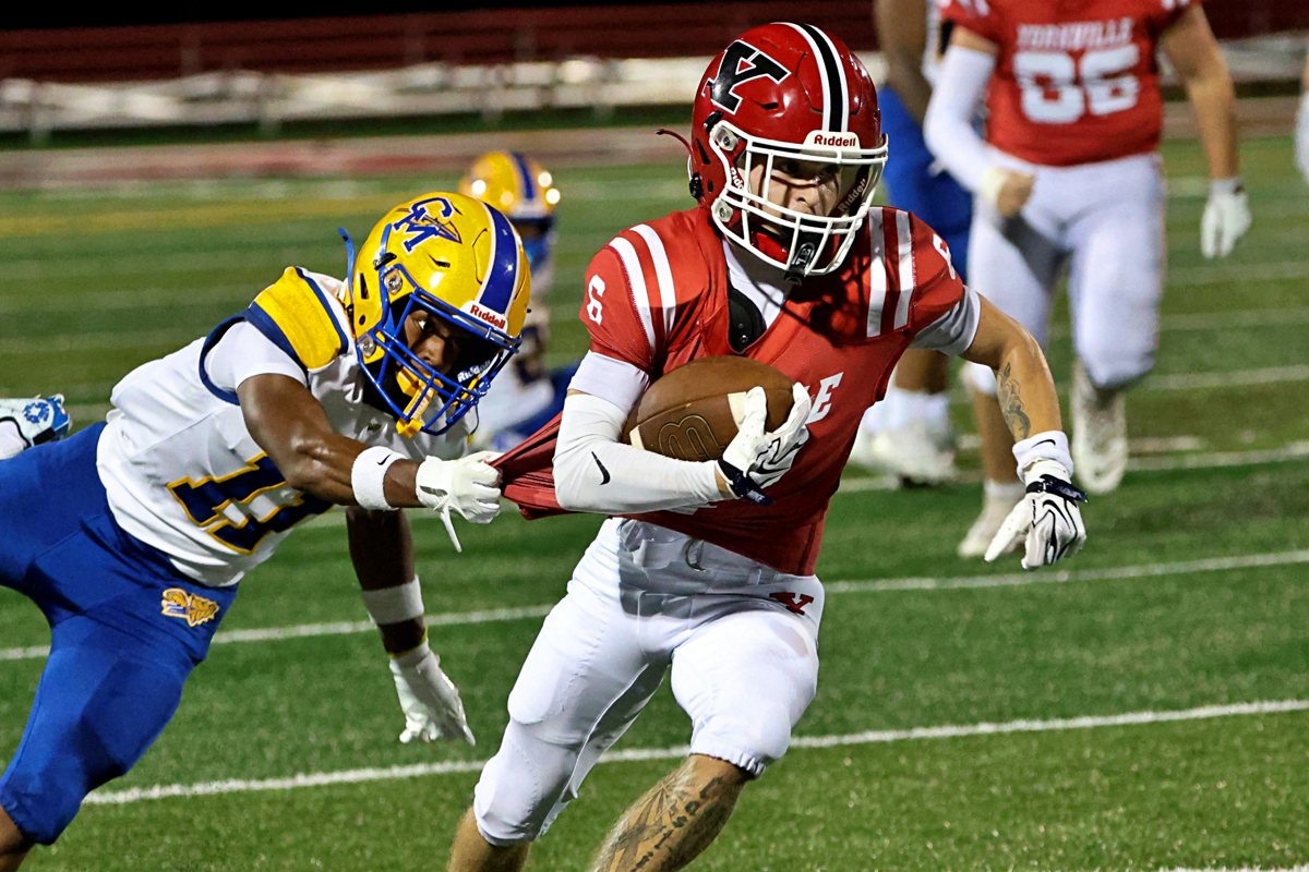 Yorkville football game action — ball carrier breaking a tackle under the lights